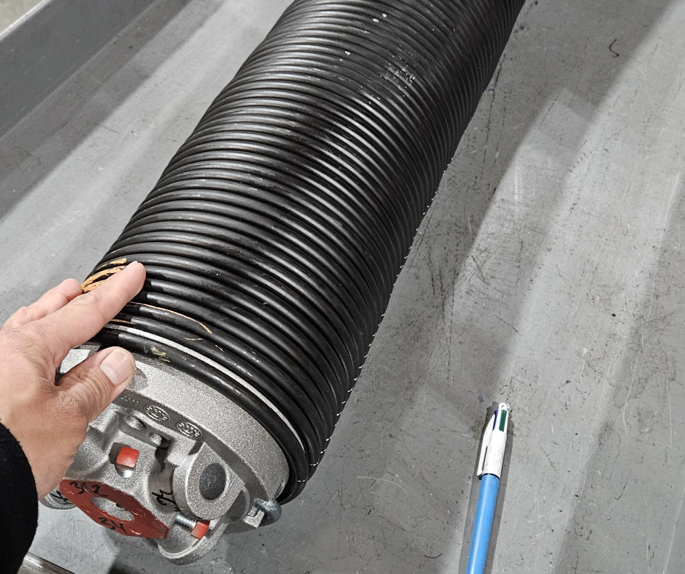 a professional technician repairing a garage door spring in Cape Coral, FL, ensuring smooth and reliable operation for homeowners.