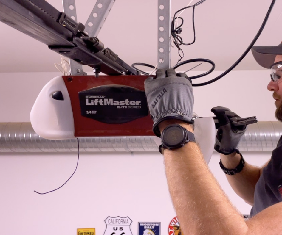 a professional technician repairing a garage door opener in Cape Coral, FL. The technician is using advanced tools to ensure safe and efficient restoration of the garage door system, providing top-rated garage door repair services in the area.