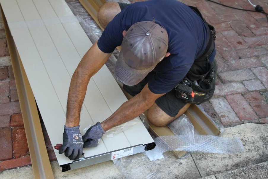 A technician replacing a damaged panel on a residential garage door.