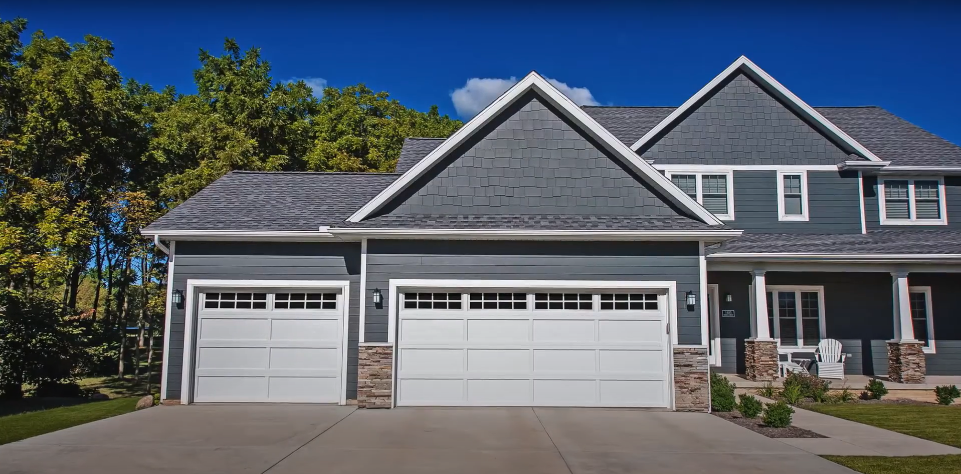 A technician performing a professional garage door repair on a residential silver roller door.